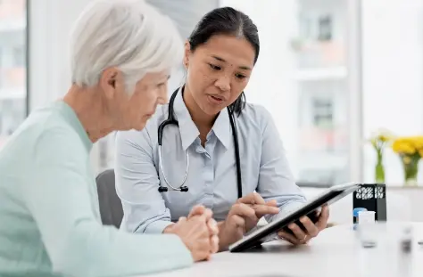 Doctor showing medical information on a digital tablet to a senior patient during a consultation Mobile