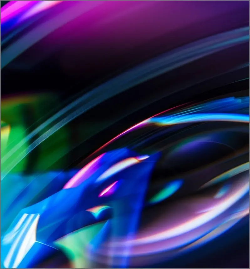 Abstract neon waves in pink, blue, and green flowing across a dark background with smooth motion blur effects